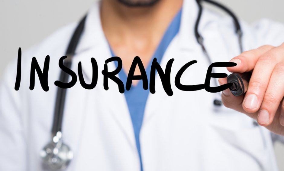 Ιατρός με στηθοσκόπιο γράφει τη λέξη Insurance